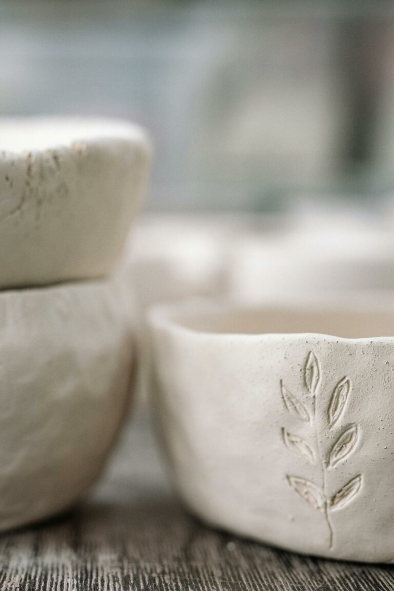 Detailed view of handmade clay pots, showcasing craftsmanship and artistic leaf imprint.